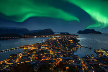 Stadt bei Nacht mit Polarlichtern im Hintergrund
