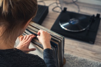 Junge Musikwissenschaft Studentin sucht eine Vinyl Platte heraus